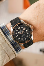 Load image into Gallery viewer, Wrist shot of a two tone dive watch in Sedna gold and Steel with ceramic black bezel