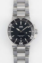 Load image into Gallery viewer, A direct, front-facing studio photograph of an Oris Aquis Date watch with a black dial, white date window at 6 o'clock, and an integrated stainless steel bracelet on a white background.
